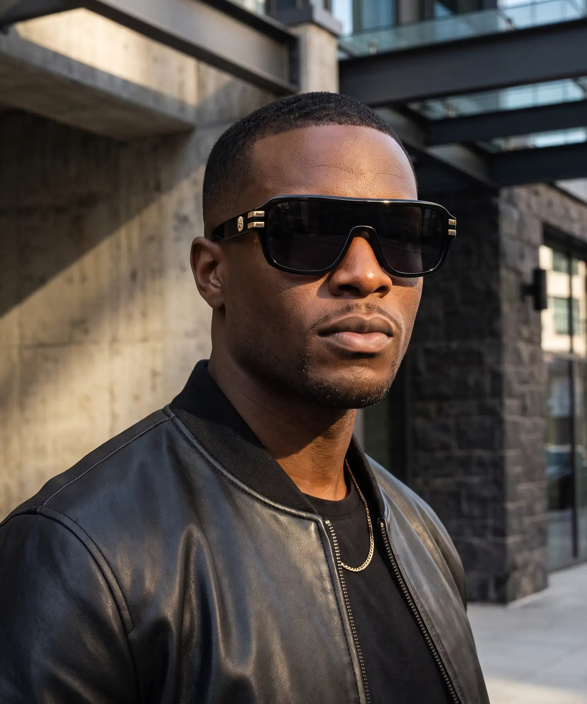 Black rectangular sunglasses with gold-tone detailing on the temples.